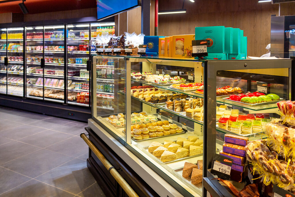 Bakery display case filled with assorted pastries, cakes, and tarts in a grocery store.